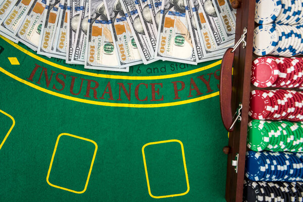 Концепция игры. Красочные фишки для покера с американскими долларами в деревянной коробке на зеленом игровом столе
.