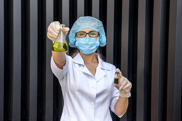 Kobieta Chemik Mundurze Ochronnym Robi Eksperyment Kolbą Niebiesko Żółtą — Zdjęcie stockowe