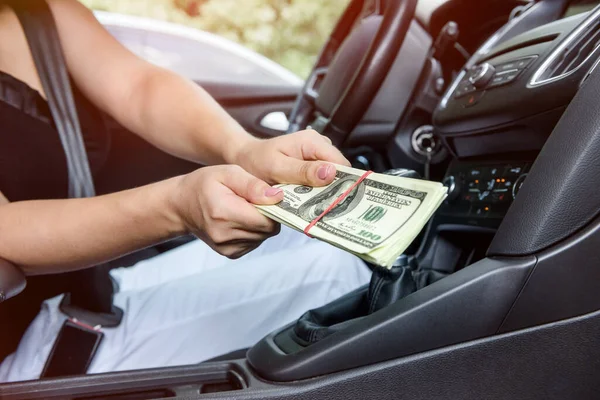賄賂の概念だ 車の中でドルのバンドルを与える女性の手を閉じる — ストック写真