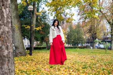 Zarif bir elbise içinde uzun boylu, güzel esmer kadın.