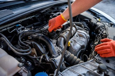 Elleri koruyucu eldivenlerle arabanın motorunu kapat. Araba tamiri kavramı
