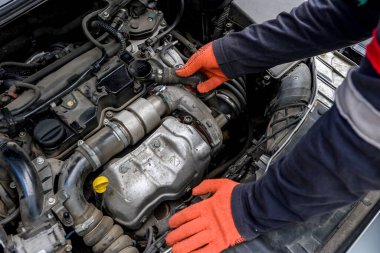 Tamircinin elleri koruyucu eldivenlerde, motor da kapalı.