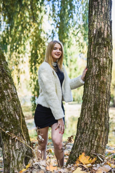 秋の森の中でポーズをとる毛皮のジャケット姿の笑顔の女性 毛皮とファッション — ストック写真