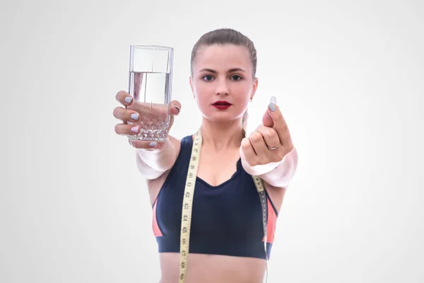 Kvinna Sportkläder Håller Piller Och Glas Vatten Isolerad Vit — Stockfoto