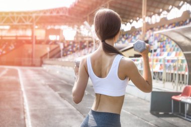 Dambılı güzel bir kadın dışarıda sabah egzersizi yapıyor. Spor ve sağlık konsepti