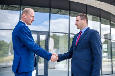 Büyük bina açılmadan önce iş ortakları el sıkışıyor.