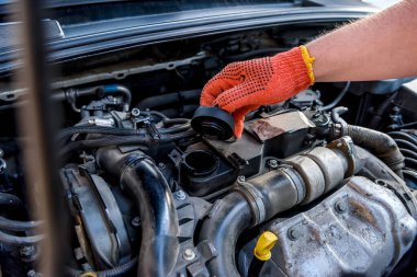 Tamircinin elleri koruyucu eldivenlerde, motor da kapalı.
