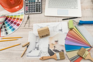 Yaratıcı tabloya örnek malzeme, şapka ve dizüstü bilgisayarla modern ev çizen mimarların üst görünümü