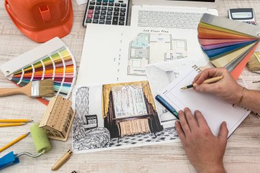 Yaratıcı tabloya örnek malzeme, şapka ve dizüstü bilgisayarla modern ev çizen mimarların üst görünümü