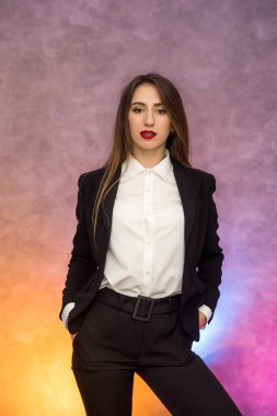 İş konsepti. Soyut arka planda poz veren zarif takım elbiseli şık bir iş kadını.