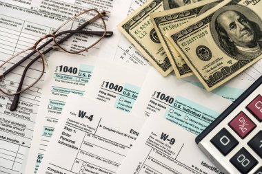 Tax form with dollar, calculator and pen
