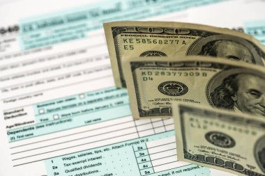 Tax form with dollar, calculator and pen