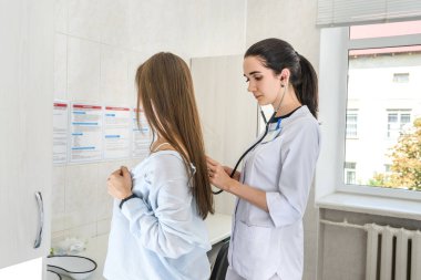 Doktor dinliyor. Hasta nefes alıyor. Yakın plan.