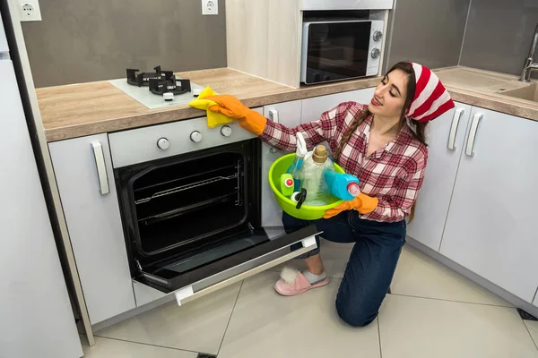 Jonge Vrouw Schoonmaken Oven Met Gele Doek Spray Keuken — Stockfoto