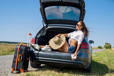 Yaz tatilinde seksi Avrupa modeli ve yaz manzarasında lüks otomobillerde poz veren güneş gözlükleri..