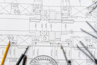 Kağıt üzerinde teknik çizimler ve çalışma araçları var. iş yeri