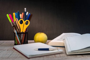 Yazı tahtasına karşı öğretmen masasında boş not defteri. eğitim kavramı.
