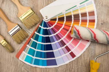 Renkli palet rehberi ve tahta üzerinde boya fırçası silindiri