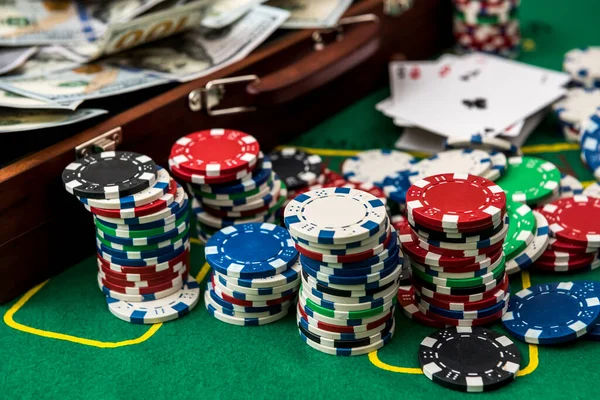 Poker chips and dollars in a case on the game table.
