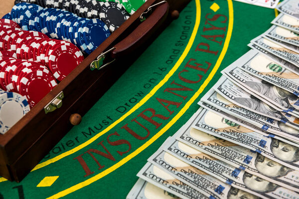 Концепция игры. Красочные фишки для покера с американскими долларами в деревянной коробке на зеленом игровом столе
.