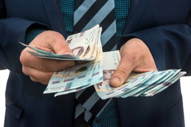 Takım elbiseli adam kar sayıyor. Erkeklerin elleri Hryvnia 'yı dönüştürür. 1000 yeni banknot, Ukrayna parası