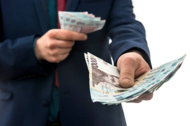 İş adamı, çok para göstererek büyük kar elde etti. Takım elbiseli bir adam Ukrayna 'nın yeni banknotlarını elinde tutuyor. 1000 Hryvnia