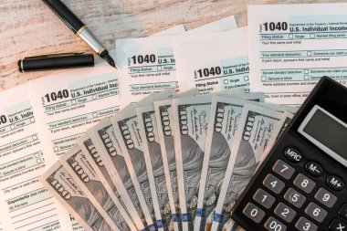 Masada 1040 vergi formu, kalem hesap makinesi ve dolar var. iş kavramı.