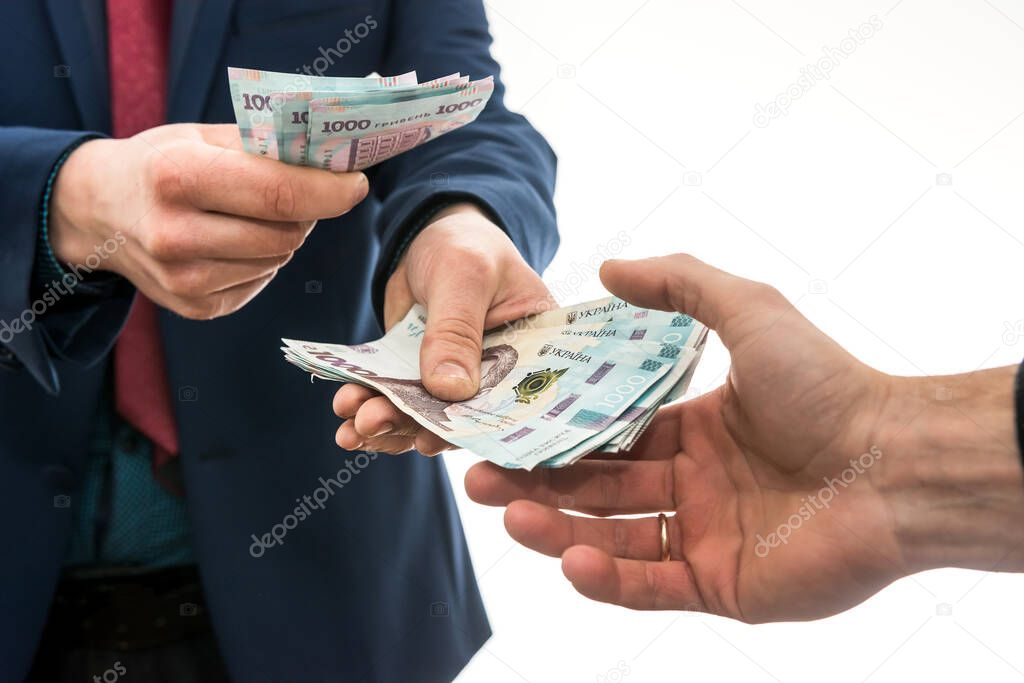 businessman gives or takes a bribe of money. Ukrainian hryvnia, new banknotes of 1000 hryvnia. Save or corruptionconcept. 