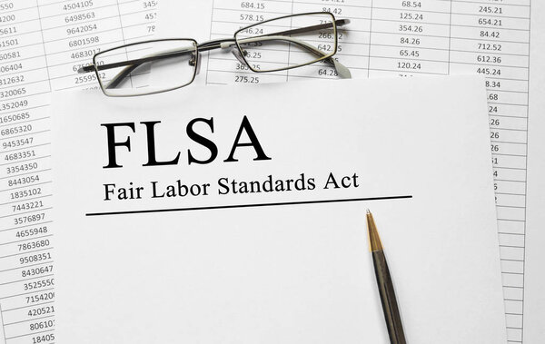 Paper with Fair Labor Standarts Act FLSA on a table