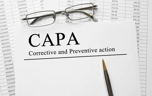 Document cu planuri de acțiune CAPA corective și preventive pe un tabel — Fotografie, imagine de stoc
