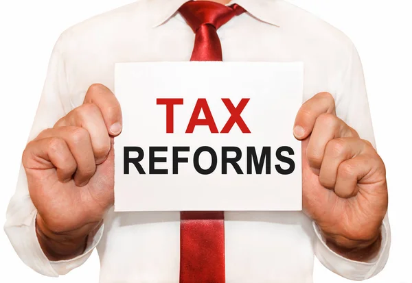 Człowiek posiadający kartę z tekstu reform podatkowych. — Zdjęcie stockowe
