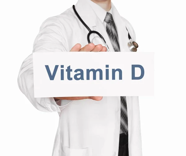 Médico sosteniendo una tarjeta con vitamina D, concepto médico — Foto de Stock
