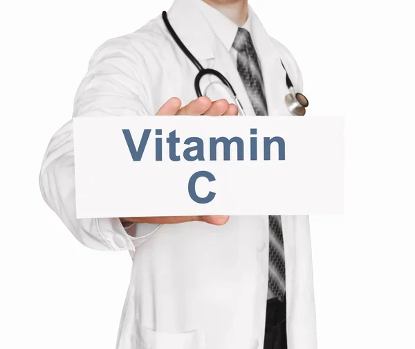 Médico sosteniendo una tarjeta con vitamina C, concepto médico — Foto de Stock