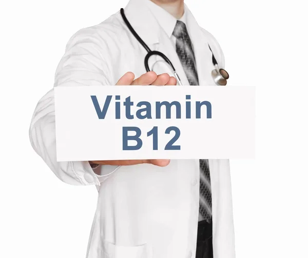 Médico sosteniendo una tarjeta con vitamina B12, concepto médico — Foto de Stock