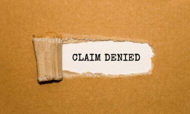 Yırtık kahverengi kağıt arkasında görünen CLAIM DENIED metni