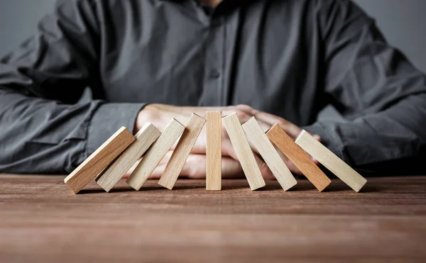 Arresto effetto domino con un domino in legno. Concetto di sicurezza e assicurazione . — Foto Stock