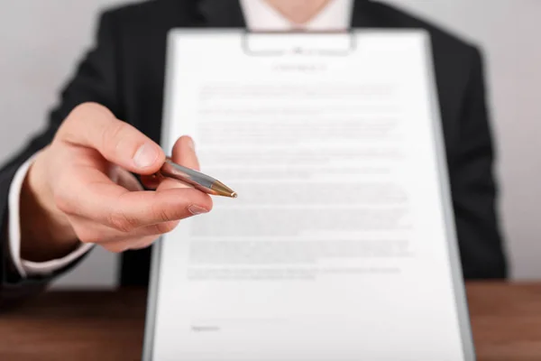 Biznesmen przekazania umowy, dołączony do schowka do podpisu, oferując długopisem w ręku. — Zdjęcie stockowe