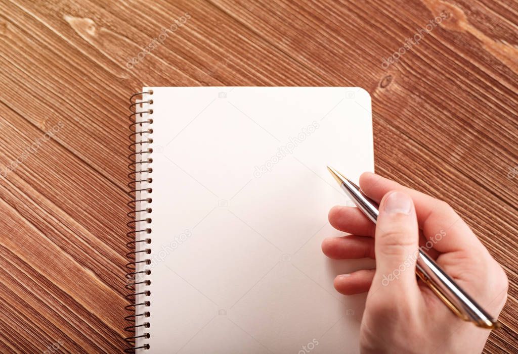 Human hand with pen prepare to writing on notebook.