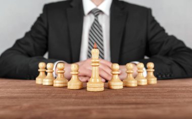 İş adamı satrancın önünde oturuyor. İş stratejisi kavramı.