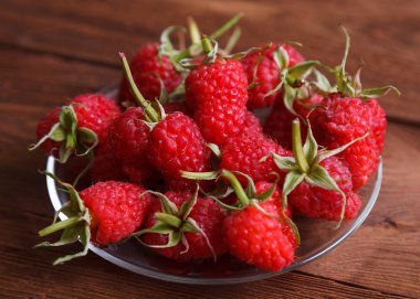 Delicious raspberries on wooden background