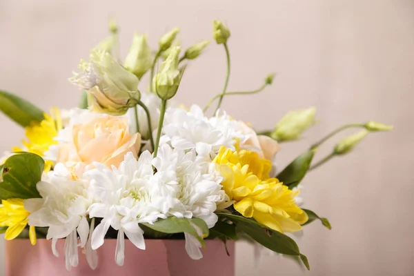 Flowers in a pink box close-up with a blurred background. Flowers as a gift, chrysanthemums, roses, as a background