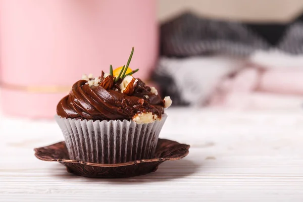 Delicioso cupcake con crema batida en el fondo de la pared beige. Concepto de productos de confitería publicitaria — Foto de Stock