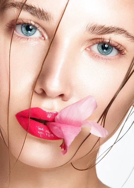 Vrouw met rode lippen en bloem — Stockfoto