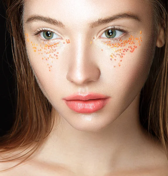 Woman with yellow sparkles on face — Stock Photo, Image
