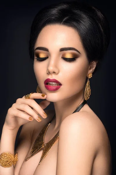 Jeune femme posant avec des bijoux en or — Photo