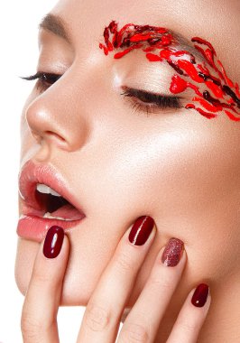 Genç bir kadın yüzüne dokunuyor