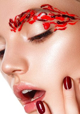 Genç bir kadın yüzüne dokunuyor