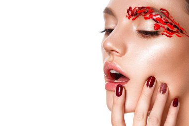 Genç bir kadın yüzüne dokunuyor