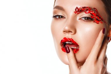 Genç bir kadın yüzüne dokunuyor