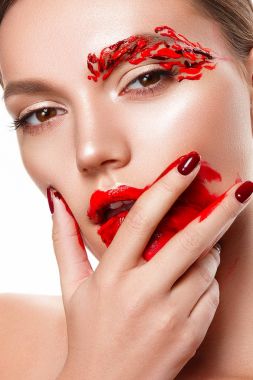 Genç bir kadın yüzüne dokunuyor